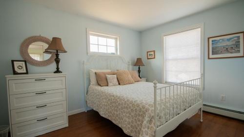a bedroom with a bed with a dresser and a mirror at Walk to Willard Beach in South Portland