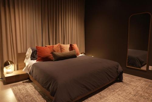 a bedroom with a bed with pillows and a mirror at Studio 27 in Magog-Orford