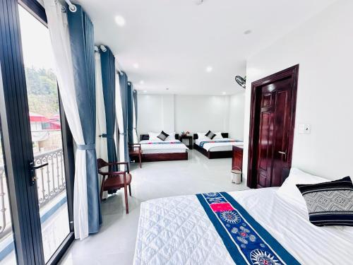a hotel room with two beds and a balcony at Mộc Hưng Homestay in Bắc Hà