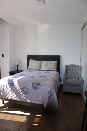 a bedroom with a bed and a chair at EON one bedroom aparment 905 in Estación Pamplona