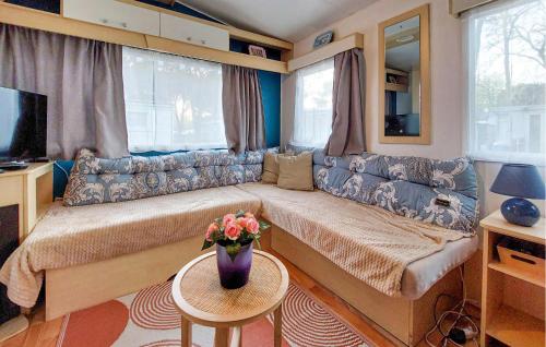 a caravan living room with a large couch and a tv at Lovely Stacaravan In La Tremblade in La Tremblade