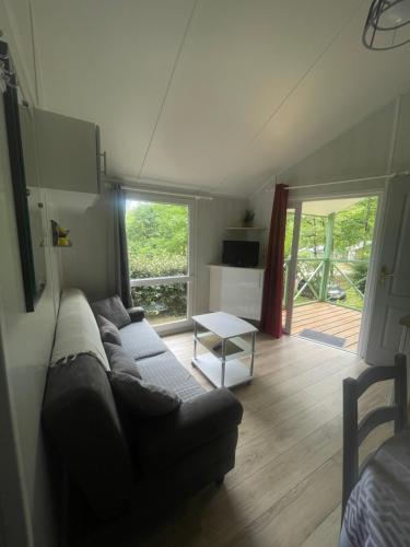 a living room with a couch and a table at Chalet cosy in Lissac-sur-Couze