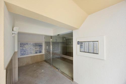 a bathroom with a walk in shower next to a wall at Casinha da Praia da Rocha in Praia da Rocha