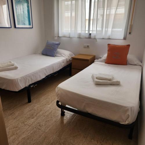 a room with two beds and a window at Cala Llobeta in Calafat