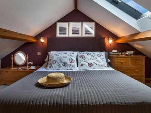 a bedroom with a bed with a straw hat on it at 1 Bed in Windermere oc-lcc57 in Ings