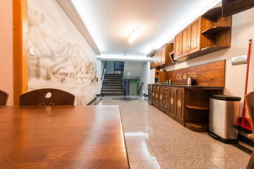 a kitchen with a long wooden table and cabinets at Dom Wczasowy Na Szczycie in Zakopane