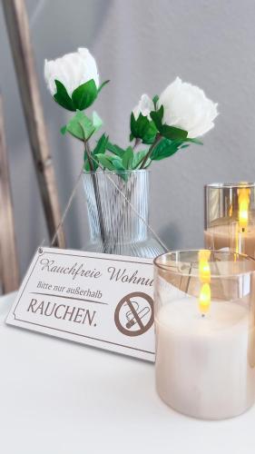a table with a candle and a sign with flowers at Emsland-Hus WG2 in Niederlangen