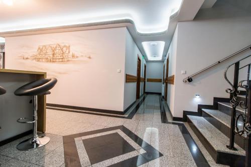 a hallway with stairs and a painting on the wall at Dom Wczasowy Na Szczycie in Zakopane