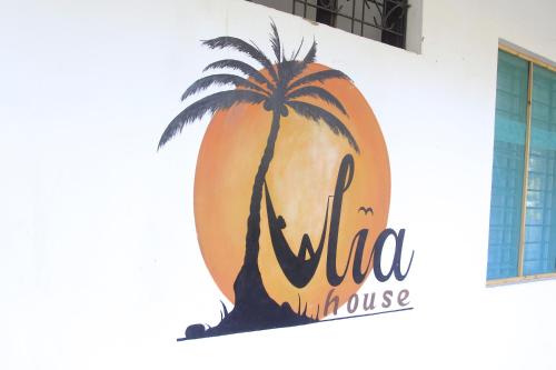 a sign on the side of a building with a palm tree at Tulia House Backpackers in Mombasa