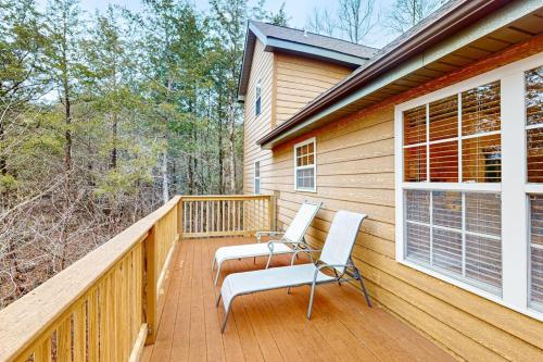 a wooden deck with two chairs on a house at Lost Creek Haven in Branson West