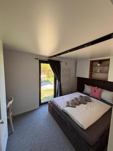 a bedroom with a large bed and a large window at Mar&Vi in Batizovce