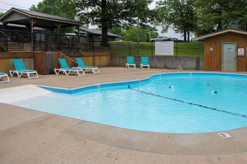a large swimming pool with blue chairs and chairs at Escape to Notch Estates in Branson West