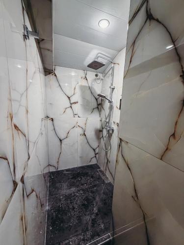a bathroom with marble walls and a walk in shower at Pushkin Hotel Yerevan in Yerevan
