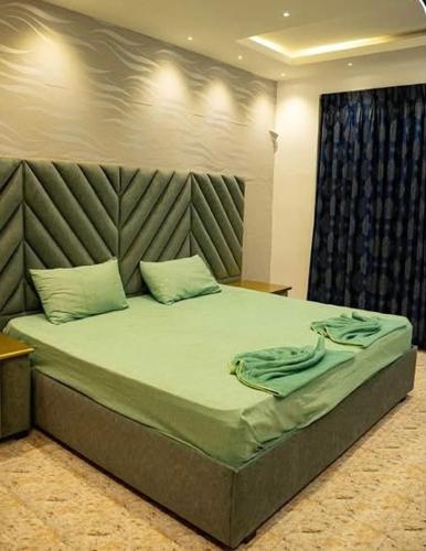 a bedroom with a large bed with a headboard at Ankola Hotel in Homagama