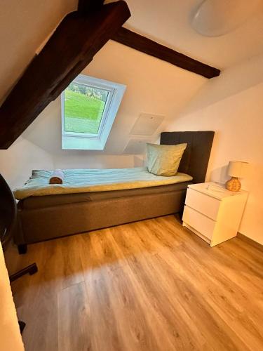 a small bedroom with a bed and a window at Haus Alpenhof in Wassen