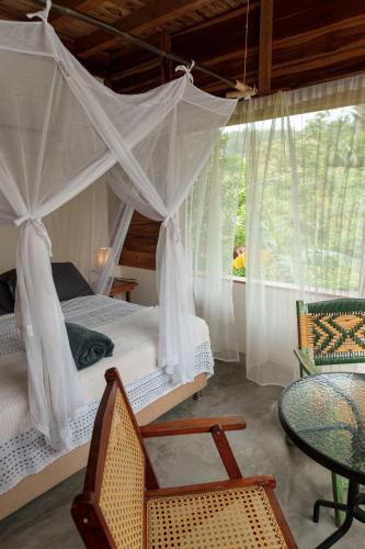 a bedroom with a canopy bed and a table and chairs at Frana Lodge in El Zaino