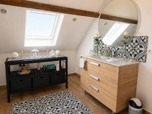 a bathroom with a black dresser and a mirror at Les oiseaux de passage - chambre d hôtes, paisible in Gaillon