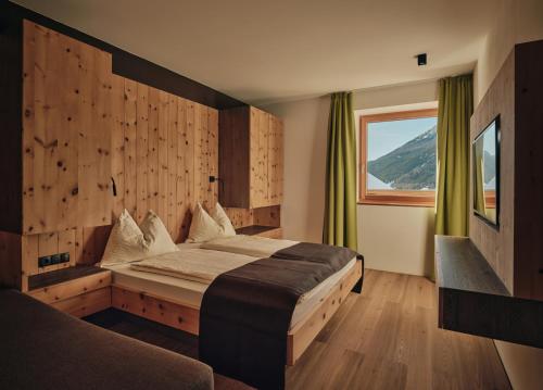 a bedroom with a large bed and a window at Lechthaler Apartments in Resia