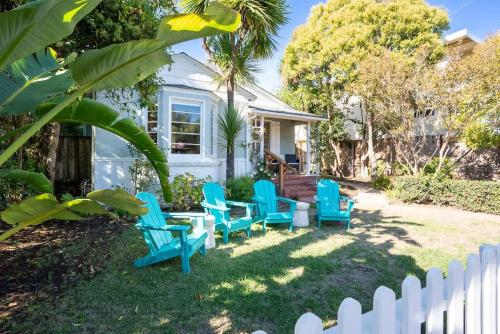 a yard with blue chairs and a white fence at Coastal Charm in Santa Cruz