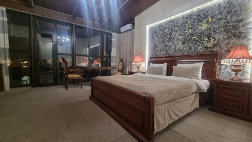 a bedroom with a large bed and a table with a chair at Grand Hotel 1902 in Baku