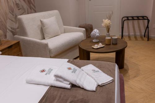 a room with a bed and a chair and a table at Palazzo Sospiri in Bisceglie