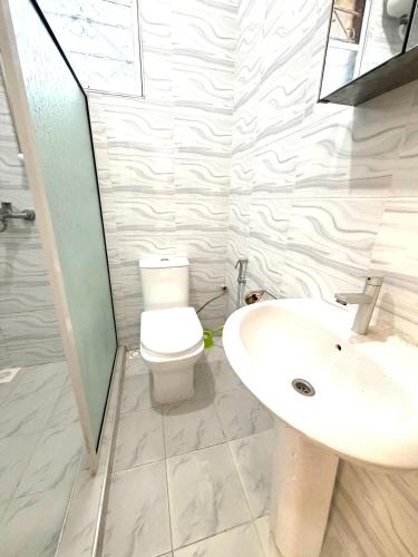 a bathroom with a toilet and a sink at The cosy corner in Zanzibar City