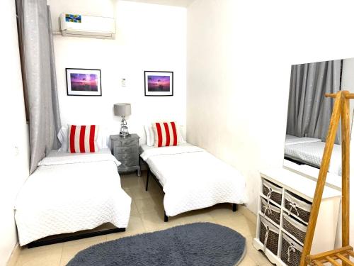 two beds with red and white pillows in a room at The cosy corner in Zanzibar City