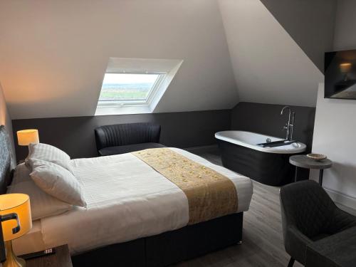 a bedroom with a bed and a bath tub at Amorist Hotel in Dunfermline