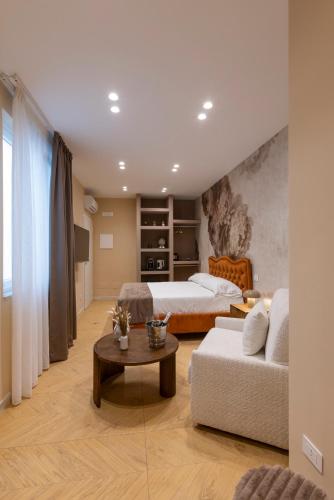 a bedroom with a bed and a couch and a table at Palazzo Sospiri in Bisceglie