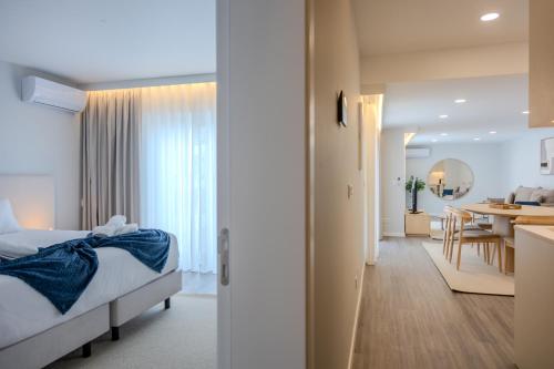 a hotel room with a bed and a dining room at Azor Signature Flats - I in Ponta Delgada