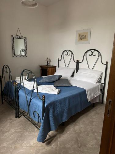 a bedroom with two beds with blue and white sheets at Masseria Fagà in Otranto