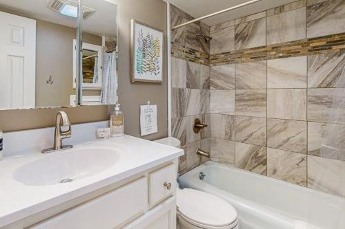 a bathroom with a sink and a toilet and a tub at The Loblolly in Bella Vista