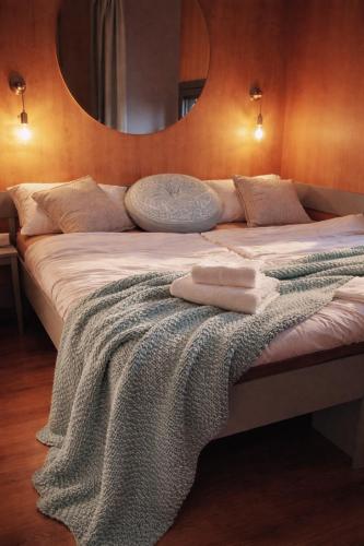a bed with a blanket on it with a mirror at CHIC Riverfront Retreat with Private Jacuzzi, BIG BERRY in Gradac