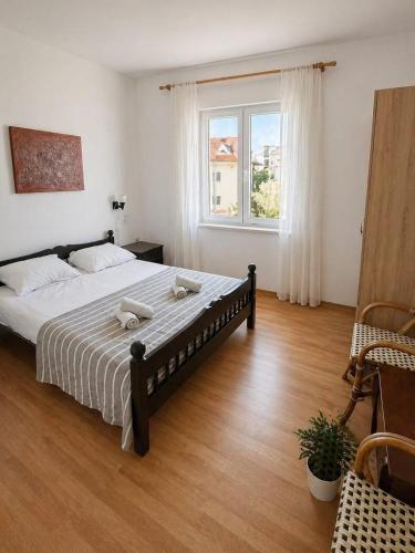 a bedroom with a large bed and a window at Apartmani Kasteljan 2, Stara Novalja in Stara Novalja
