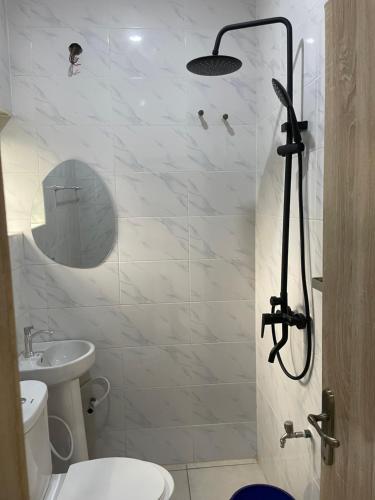 a bathroom with a shower with a toilet and a sink at Lloyd Hotel and Suites in Benin City
