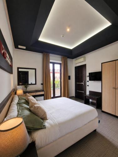 a bedroom with a large bed and a television at Boteco B&B in Bacoli