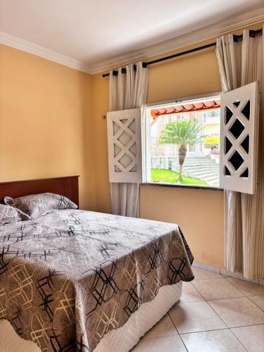 a bedroom with a bed and a window at Casa das Petúnias in Ubajara