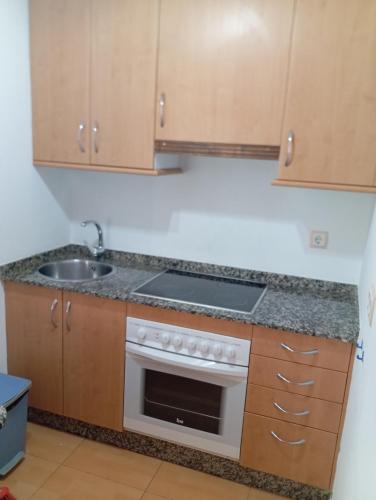 a kitchen with a sink and a stove at Hotel Villa de Ares in Ares