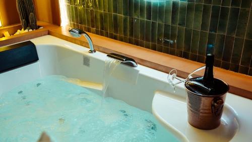 a bath tub with a bottle of wine in it at La Casa Mexicana in Alfortville