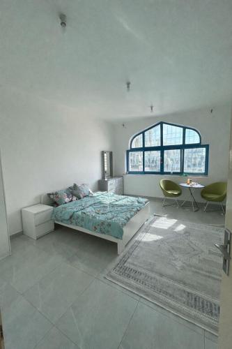 a bedroom with a bed and a table and a window at Vi Home Stay Corniche in Abu Dhabi