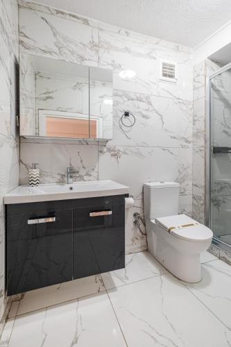 a white bathroom with a toilet and a sink at Oban Suites Istanbul in Istanbul