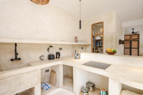 a kitchen with a counter and a counter top at Nishati - Private Beach Villa in Matemwe