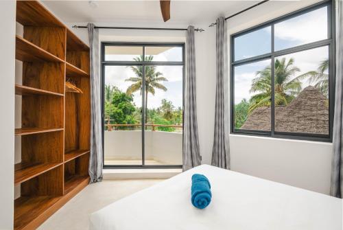 a bedroom with a bed and a large window at Nishati - Private Beach Villa in Matemwe