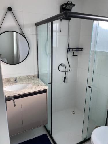 a bathroom with a glass shower and a sink at Refúgio Aconchegante & Charmoso! in Aracaju