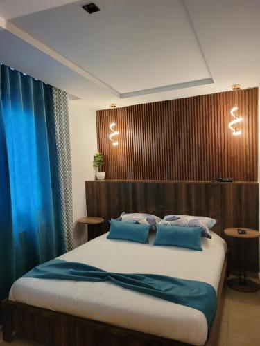 a bedroom with a large bed with blue pillows at Impavid Hotel in Gabès