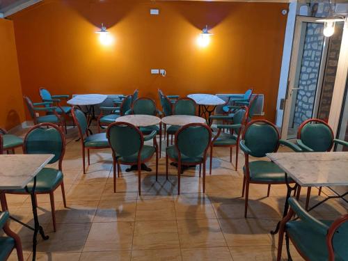 a dining room with tables and chairs and a wall at Hotel BETHEL in Nevers