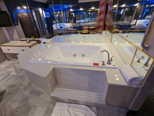 a large bathroom with a tub with a sink at Hickory West Inn in Hickory Hills