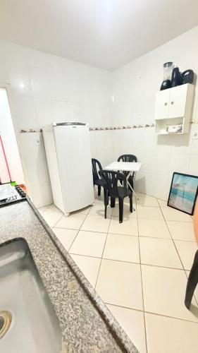 a kitchen with a table and chairs and a refrigerator at Casa para 9 pessoas a poucos passos do Santuário de Aparecida in Aparecida