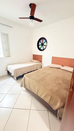 a bedroom with two beds and a ceiling fan at Casa para 9 pessoas a poucos passos do Santuário de Aparecida in Aparecida
