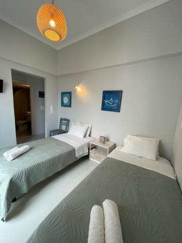 a bedroom with two beds and a room with aupuncture at Passos Rooms in Parikia